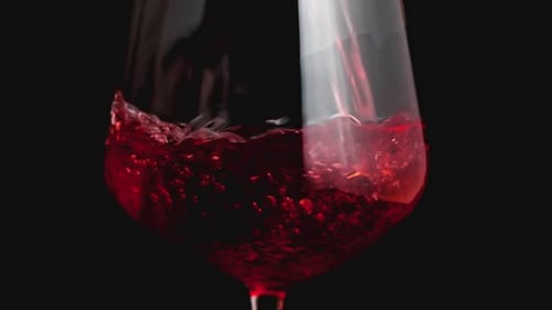 Rotwein bildet eine schöne Welle. Weinguss im Weinglas über schwarzem Hintergrund