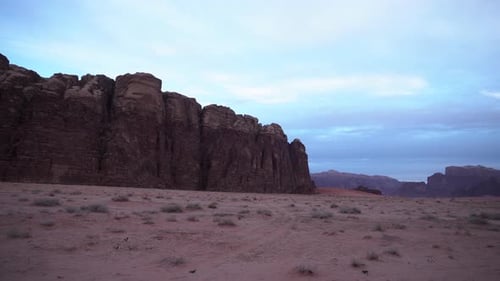 A Panoramic Shot of Wadi Rum Desert Canyon With Sand, Mountains and White Clouds in the Background