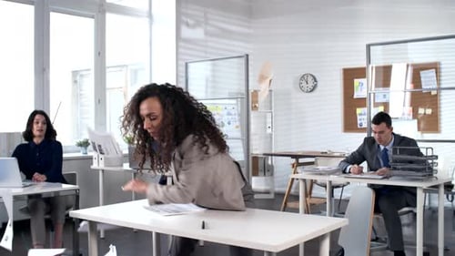 Femme d'affaires s'énerve au travail et commence à danser sur le bureau