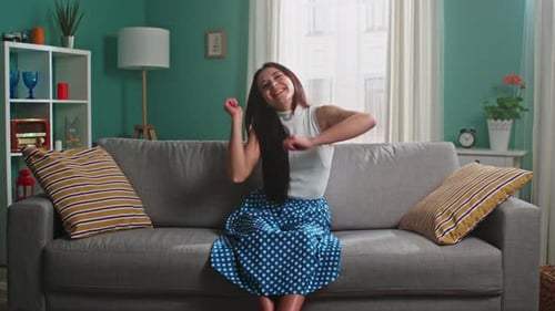 Young Woman Dancing on Sofa in Living Room