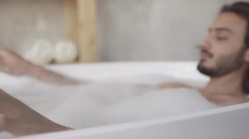 Man Relaxing Peacefully in a Bubble Bath