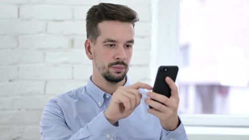 Creative Young Man Using Smartphone Application
