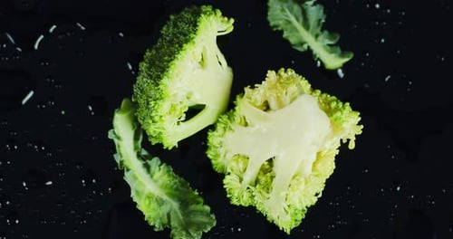 Cut pieces of broccoli on dark surface