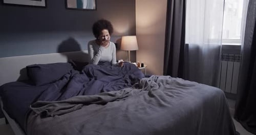 Woman Sitting in Bed Sick With a Cold