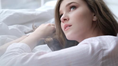 Side View Portrait of Young Cheerful Beautiful Woman Smiling While Lying in Bed Early Morning After