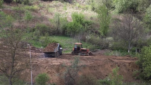 Bulldozer and Dump Truck Preparing Land