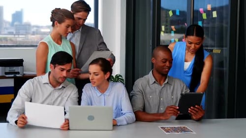 Team Gathers Around Table in Bright Office