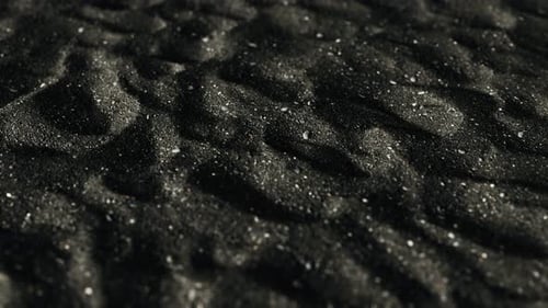 Black Volcanic Sand Ripples with White Particles Close-up Background Loop