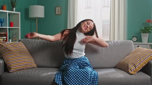 Happy Woman Dancing on Couch at Home