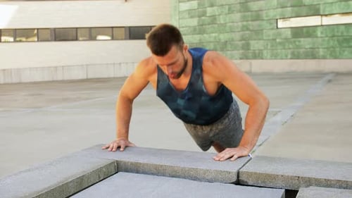 Young Man Doing Push Ups on City Street