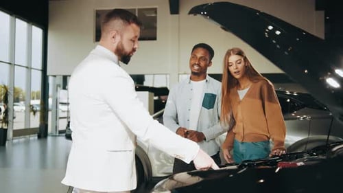 Car Salesman Explains Vehicle Features to Couple
