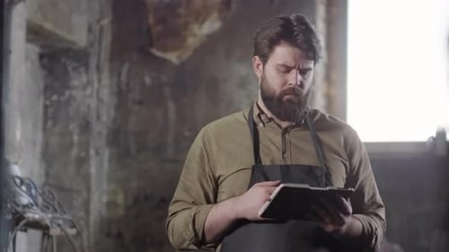 Blacksmith Using Tablet in Workshop