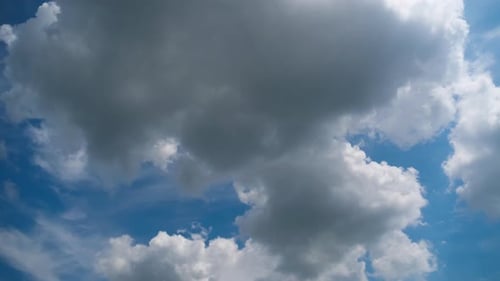 Billowing White Clouds Float Across Blue Sky