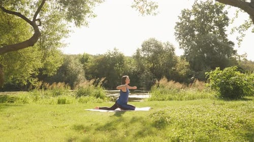 Morning yoga in park. Meditation concept. Young serene woman meditating in summer park