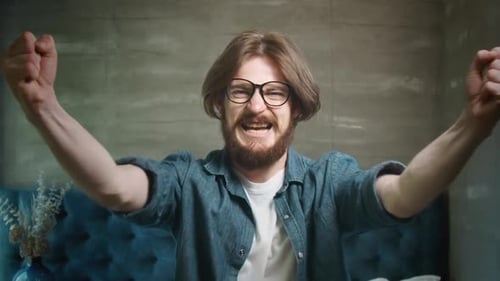 Excited Young Adult Man Celebrating with Raised Arms