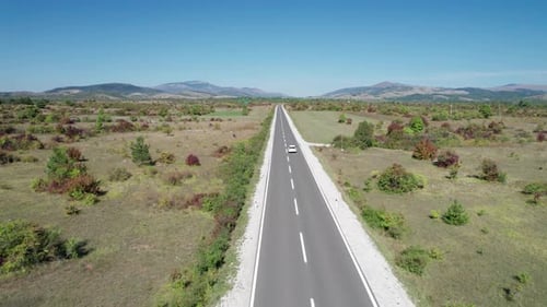 Aerial View Empty Asphalt Road on the Plateau Between Green Fields Highland Way