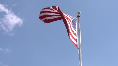 Waving American Flag Against Clear Blue Sky