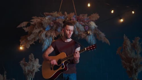 Young Adult Plays Acoustic Guitar Indoors