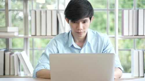 Young Adult Works on Laptop at Home