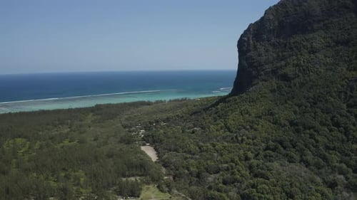 Luftaufnahme einer Person beim Gleitschirmfliegen zwischen den Bergen, Mauritius.