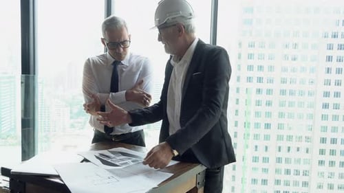 Architects Reviewing Building Plans in Bright Office