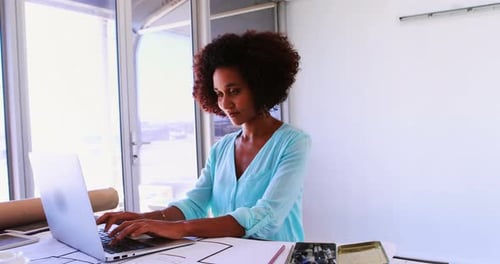 Female architect working on blueprint over drafting table 4k