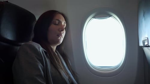 Woman Sleeping on an Airplane by the Window
