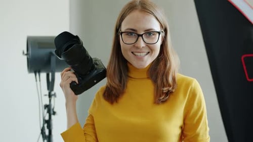 Portrait of Successful Female Photographer Beautiful Woman Holding Camera in Studio