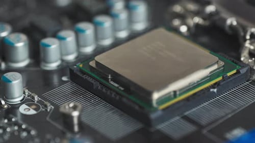 Repairman's hand installs the CPU processor into a socket on the motherboard.