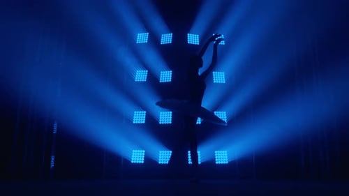 Woman Practicing Ballet on Blue-Lit Stage