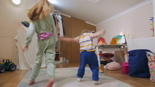 Siblings Dancing Together in Bedroom with Natural Light