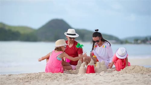 Parents with Kids Play Making Sand Castle at Tropical White Beach