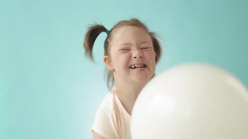 Girl Plays with Balloons at Birthday Party