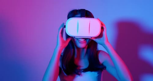 Young Woman Experiences Virtual Reality in Neon Lighting