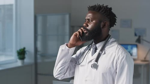 Male Doctor Talking on Phone in Office