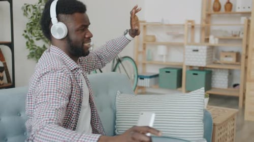 Enthusiastic Young Man Dancing at Home to Music