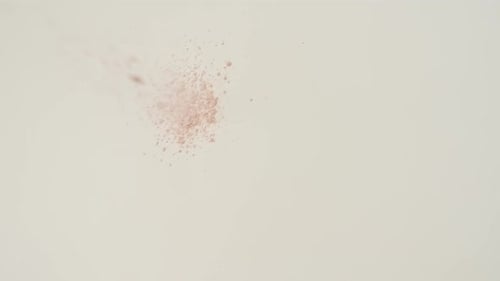 Red Powder Falling onto a White Surface
