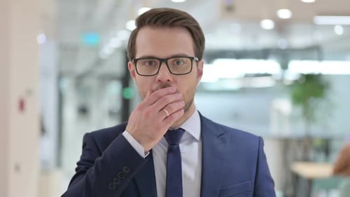 Shocked Businessman Covers Mouth in Surprise