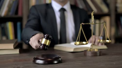 Close Up Shoot of Judge Hand Bang the Gavel While Reading Book