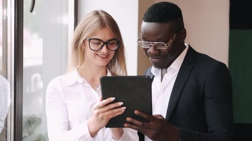 Professionals Reviewing Tablet in Office Setting