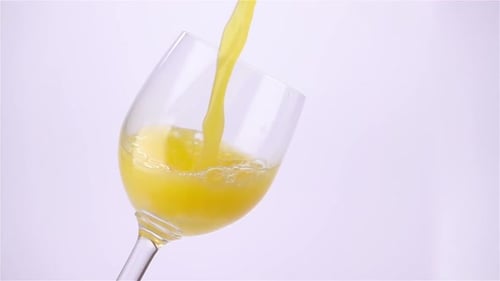 Bright Yellow Liquid Poured into Wine Glass Close-up