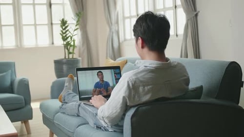 Young Adult Video Calling on Laptop at Home