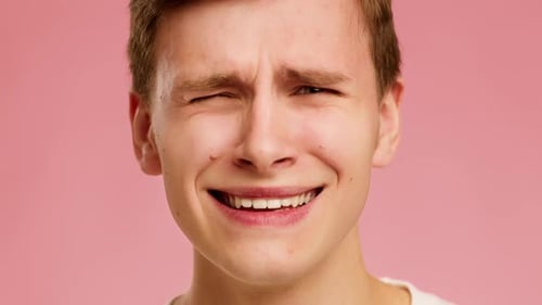 Man Makes Emotive Faces on Pink Background