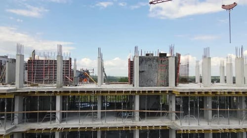 Tower Cranes and Workers at High Concrete Residential Building Under Construction