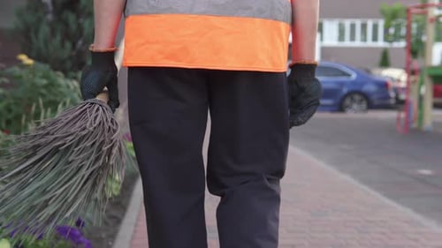Un concierge de rue ramasse les ordures. La propreté et l'ordre dans la cour dépendent du concierge.