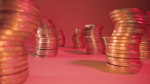 Piles incurvées de pièces dorées brillantes sur une table au feu rouge