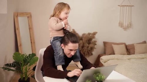 Ein Mann versucht zu Hause hinter einem Laptop zu arbeiten