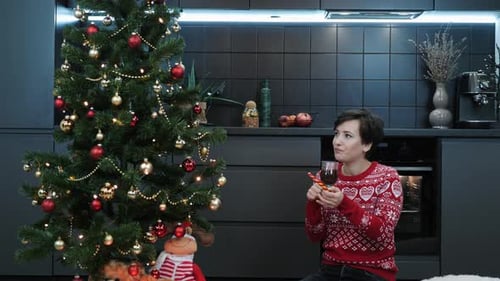 Woman Drinks Wine by Christmas Tree