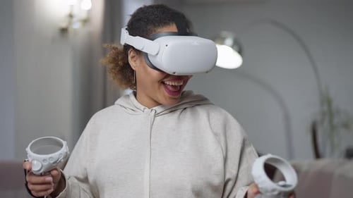 Woman Wearing VR Headset Holding Controllers Smiling