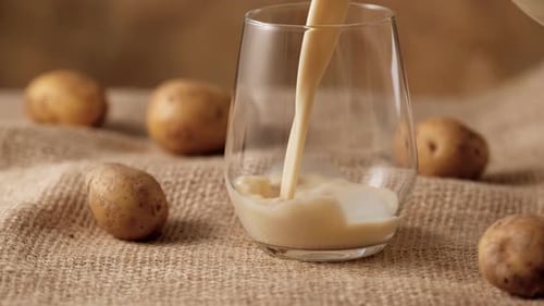 Potato Milk Being Poured into Glass Cup